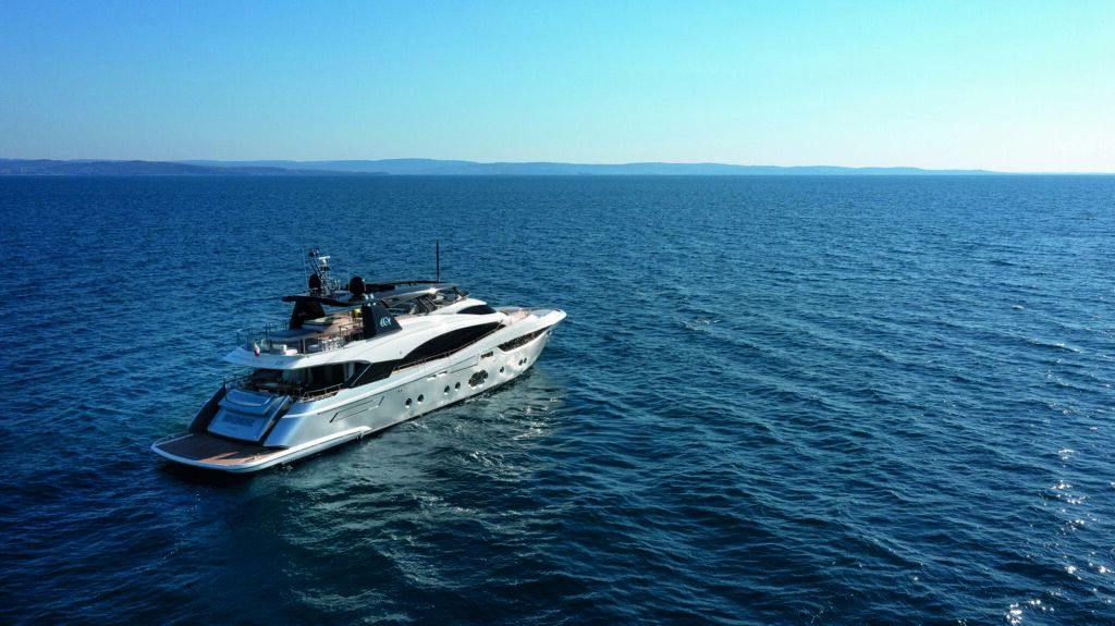 Redleaf beach sydney: Aerial view of the white motor yacht Sirenuse cruising on deep blue open water with a distant coastline