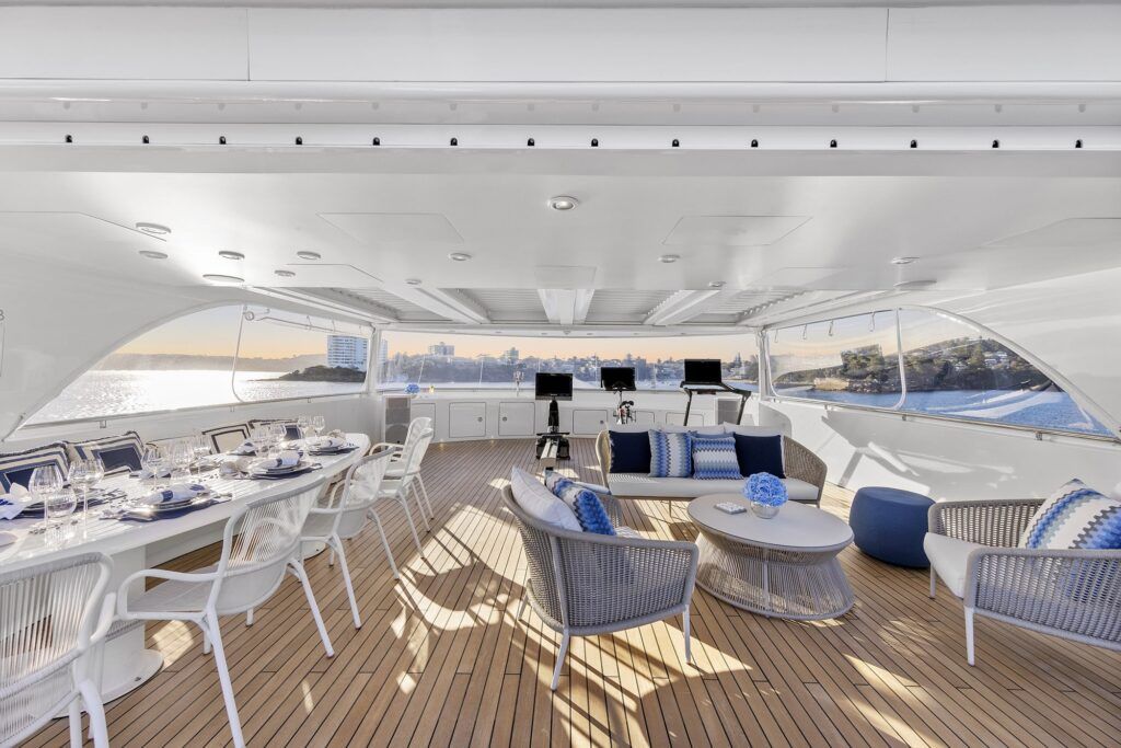 Party boat rentals: The photograph showcases the elegant upper deck of a luxury yacht, featuring a beautifully set dining