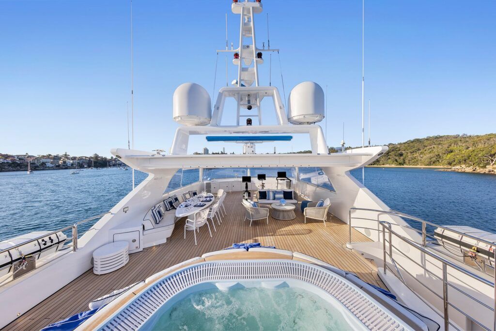 Nye harbour charters: The photograph captures the opulent deck of a luxury yacht, featuring a hot tub in the foreground with