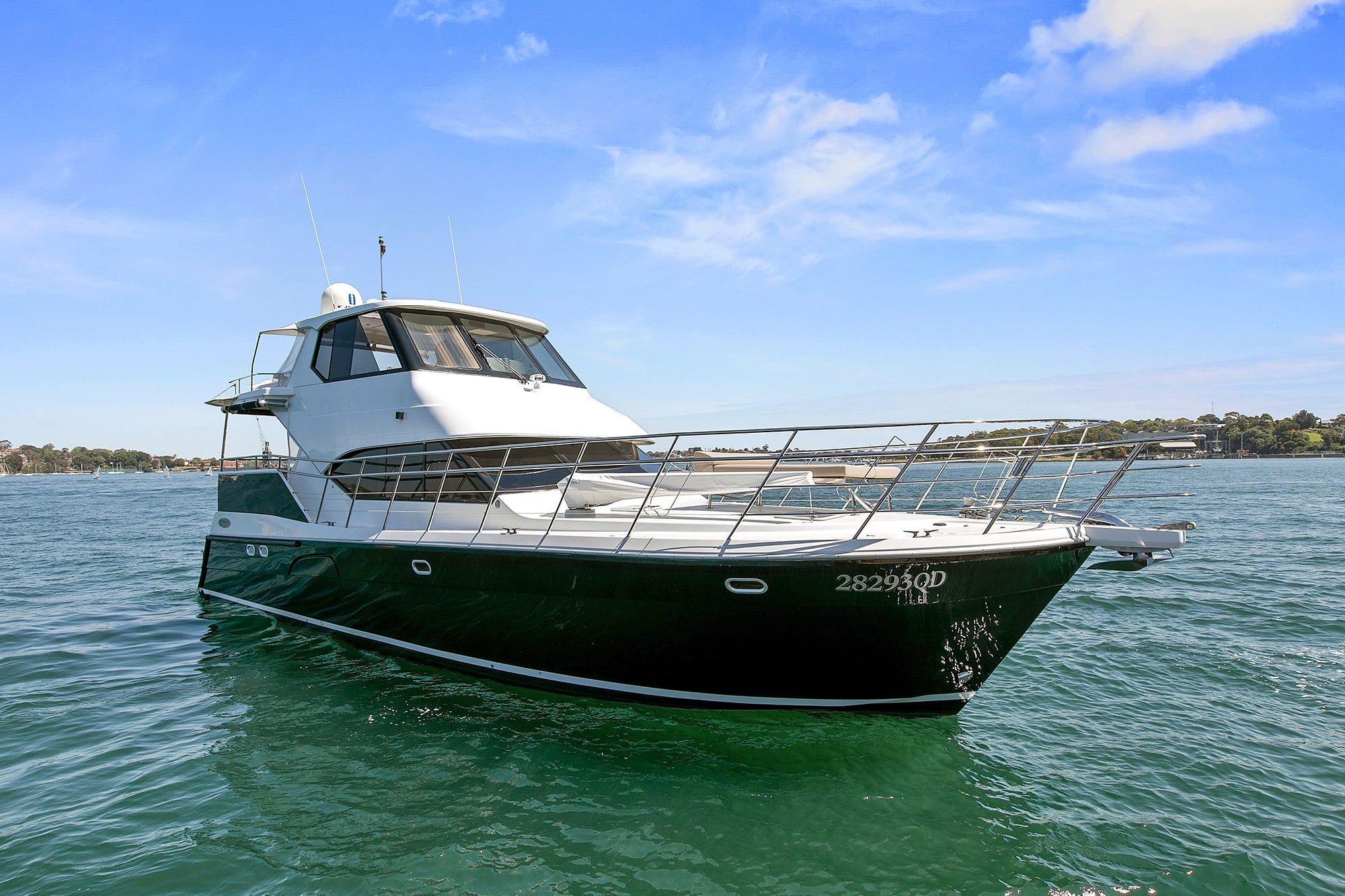The motor yacht Seas the Day at anchor on calm green water