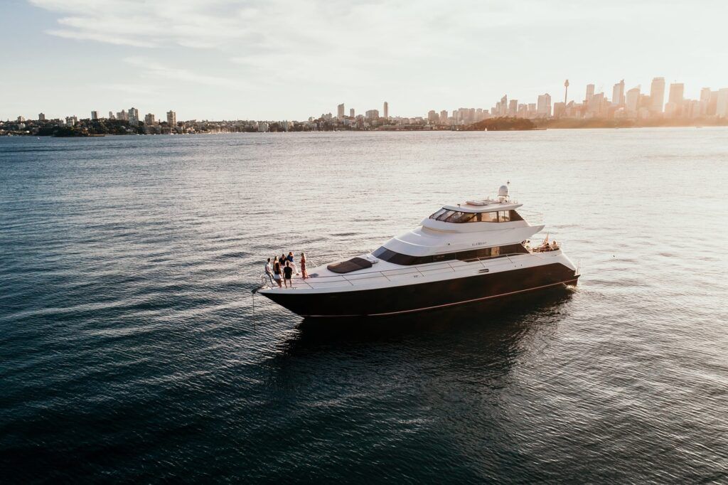 Nye harbour charters: A luxurious yacht glides through the tranquil waters of Sydney Harbour, with the city’s iconic skyline