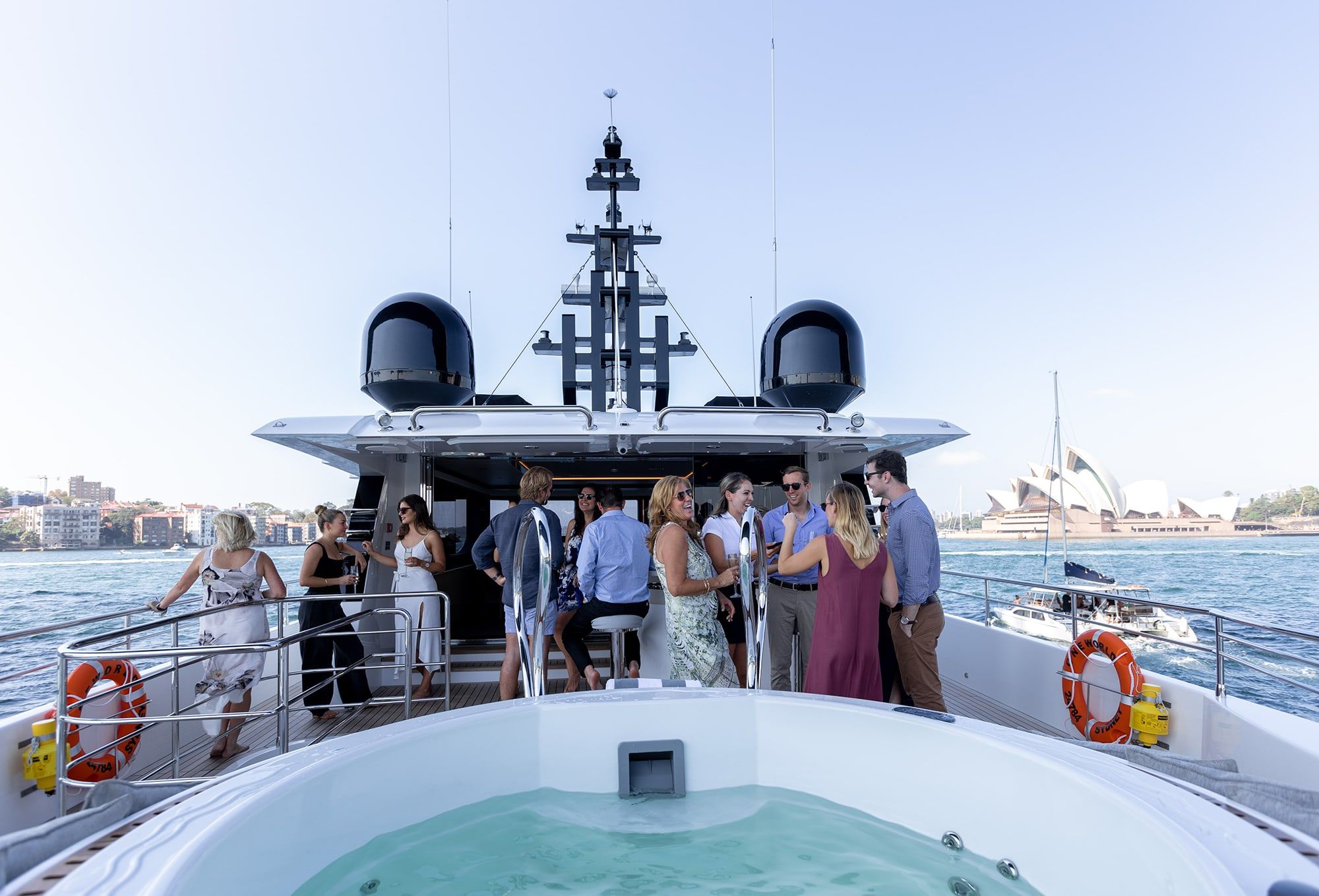 Guests with drinks on the upper deck of superyacht Oneworld