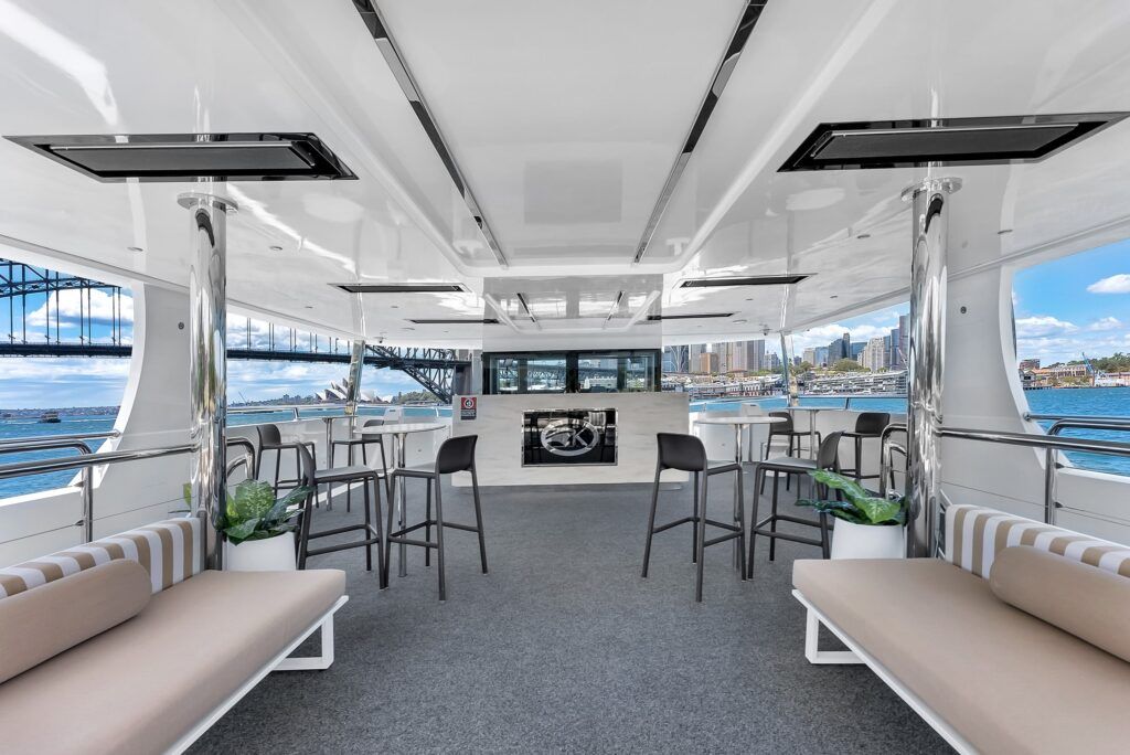 Lookouts in sydney: Covered rear deck of the vessel Karisma 2 with bar tables, stools and bench seating overlooking a